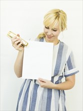 Studio shot of woman holding blank paper and stapler