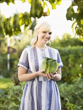 Woman wearing striped dress working in vegetable garden