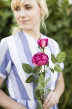 Woman holding purple rose