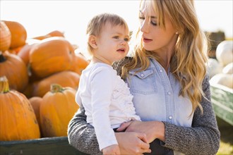 Mother and daughter (12-17 months) with pumpkins in background