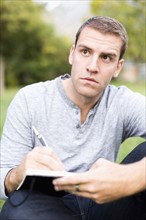 Portrait of young man writing journal