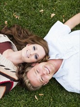 Portrait of young couple lying in grass