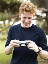 Portrait of young man with camera