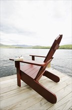 Book and chair on lake side dock