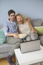 Couple watching movies on laptop.