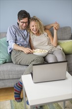Couple watching movies on laptop.