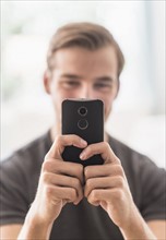 Close-up of man using mobile phone.