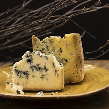 Blue cheese slices on plate, studio shot.