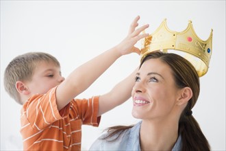 Son (6-7) putting crown to mother's head
