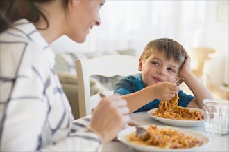 Mother and son (6-7) eating spaghetti