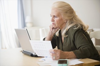 Senior woman paying bills online