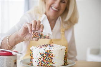 Senior woman decorating cake