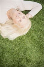 Senior woman lying on grass