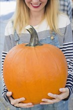 Mid-section of woman showing pumpkin