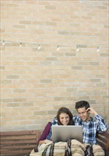Young couple using laptop on roof