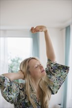 Blond woman stretching at home