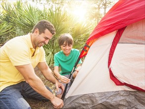 Father and son (12-13) setting up tent