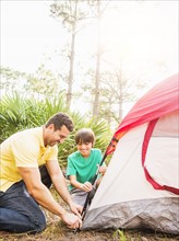 Father and son (12-13) setting up tent