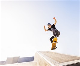 Man jumping on skateboard in skatepark
