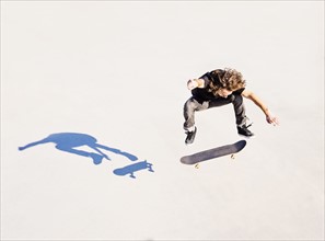 Man jumping on skateboard in skatepark