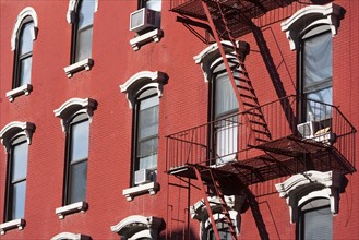 Facade of red building with fire escape