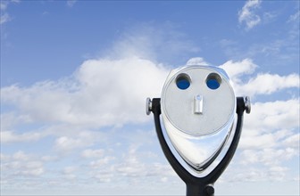 View of coin-operated binoculars against sky and clouds