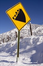 View of road sign and snowcapped mountain