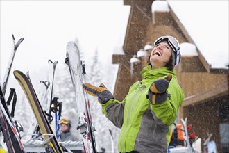 Woman wearing ski googles with hands raised