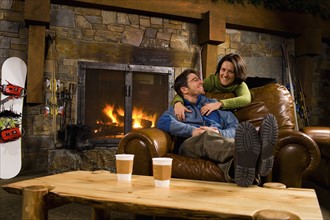 Man and woman hanging out in front of fireplace
