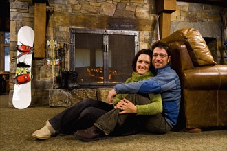 Man and woman hanging out in front of fireplace
