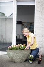 Woman planting flowers outdoors