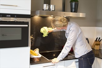 Mid-adult woman cleaning kitchen