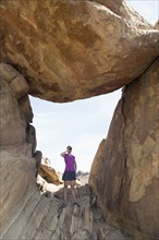 Woman visiting Balanced Rock, looking through binoculars
