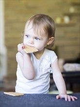 Girl (12-17 months) eating water cracker