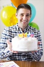 Portrait of mid-adult man with birthday cake
