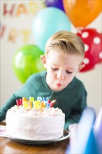 Boy (2-3) blowing out candles