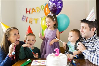 Family with three children (2-3, 4-5) celebrating birthday