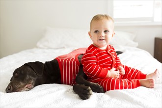 Boy (2-3) with dog in bedroom