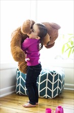 Girl (4-5) hugging teddy bear