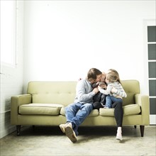 Family embracing on sofa