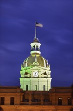 City hall clock tower illuminated in green