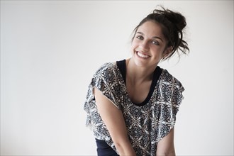 Portrait of teenage girl (14-15) smiling in studio.