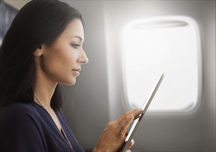Young woman using tablet on plane.