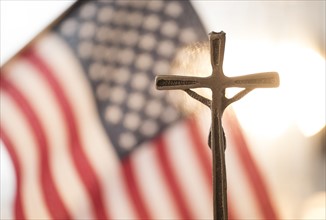 Cross with American flag in background.