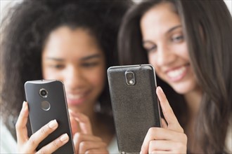 Teenage girls (14-15, 16-17) using smart phones.