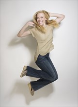Portrait of mid-adult woman jumping.