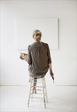Female artist painting in studio.