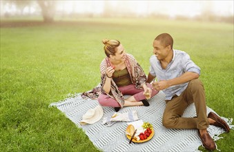 Mid adult couple having picnic in park.