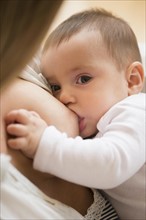 Mother breastfeeding her daughter (2-5 months)