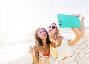 Female friends taking selfie on beach